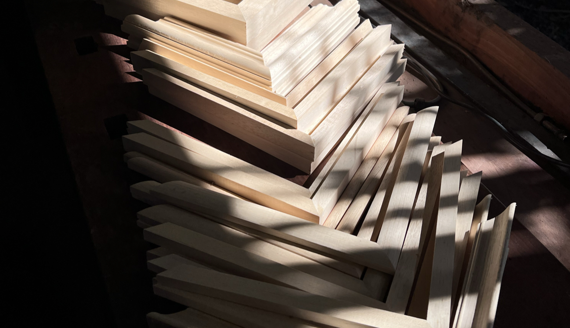 Muestrario de molduras de madera y banco de trabajo en el taller Estudio Castelar